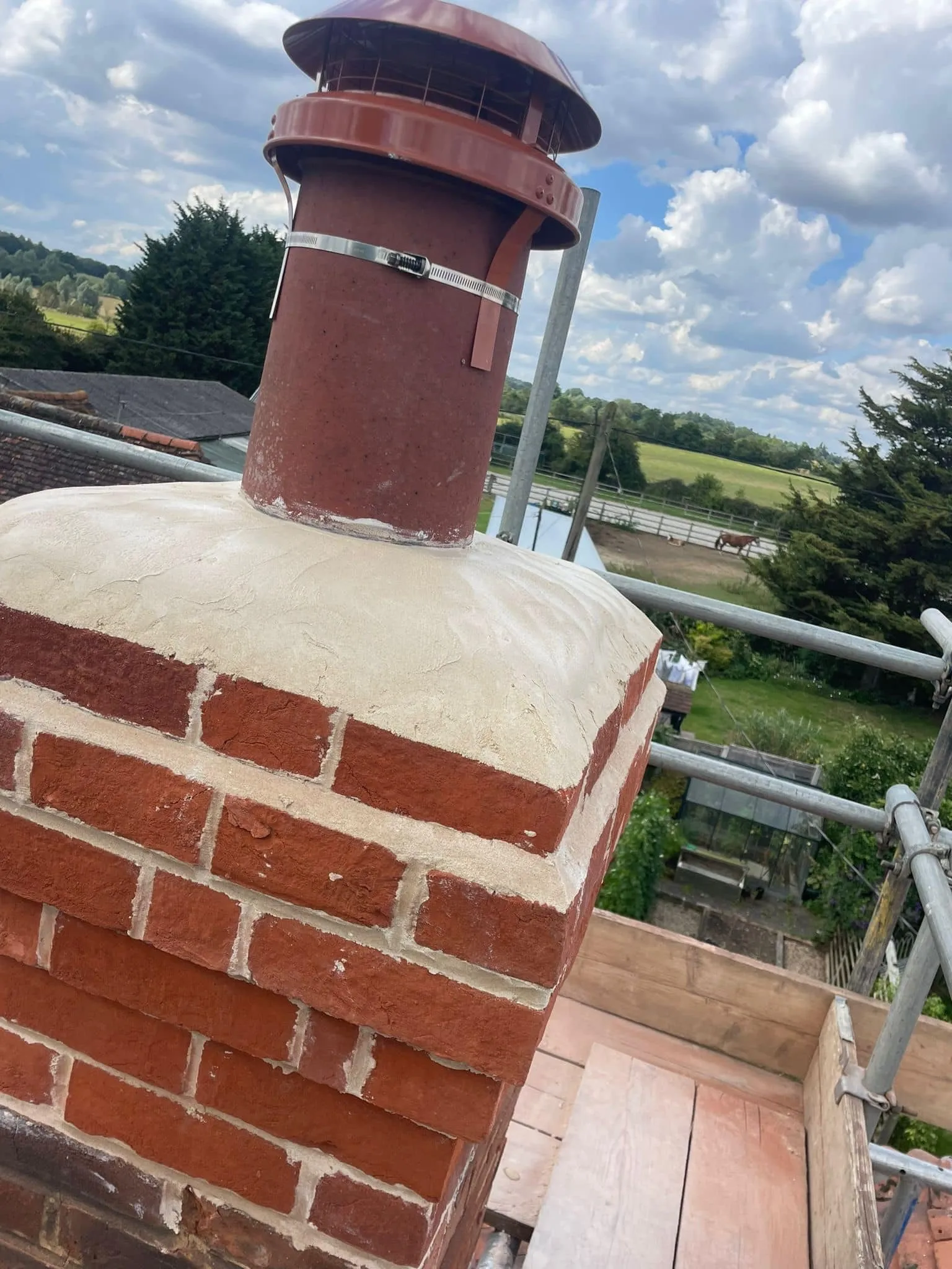 Red brick chimney repair on a residential roof